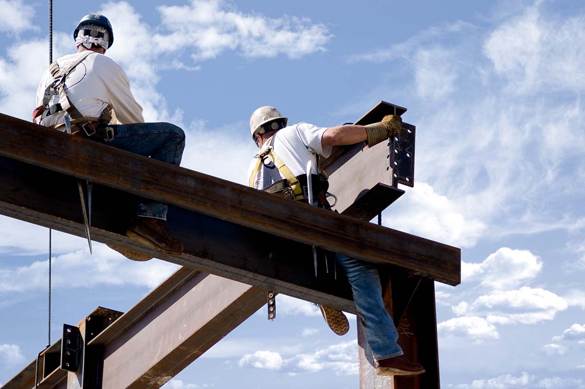 Steal erectors constructing a building with I beams